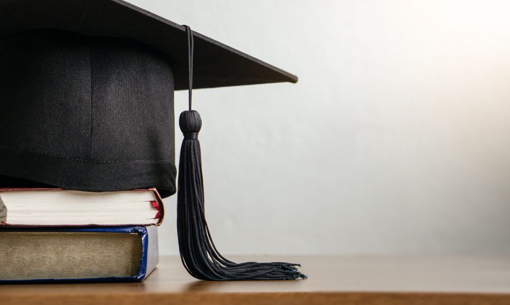 mortarboard on books on a table.